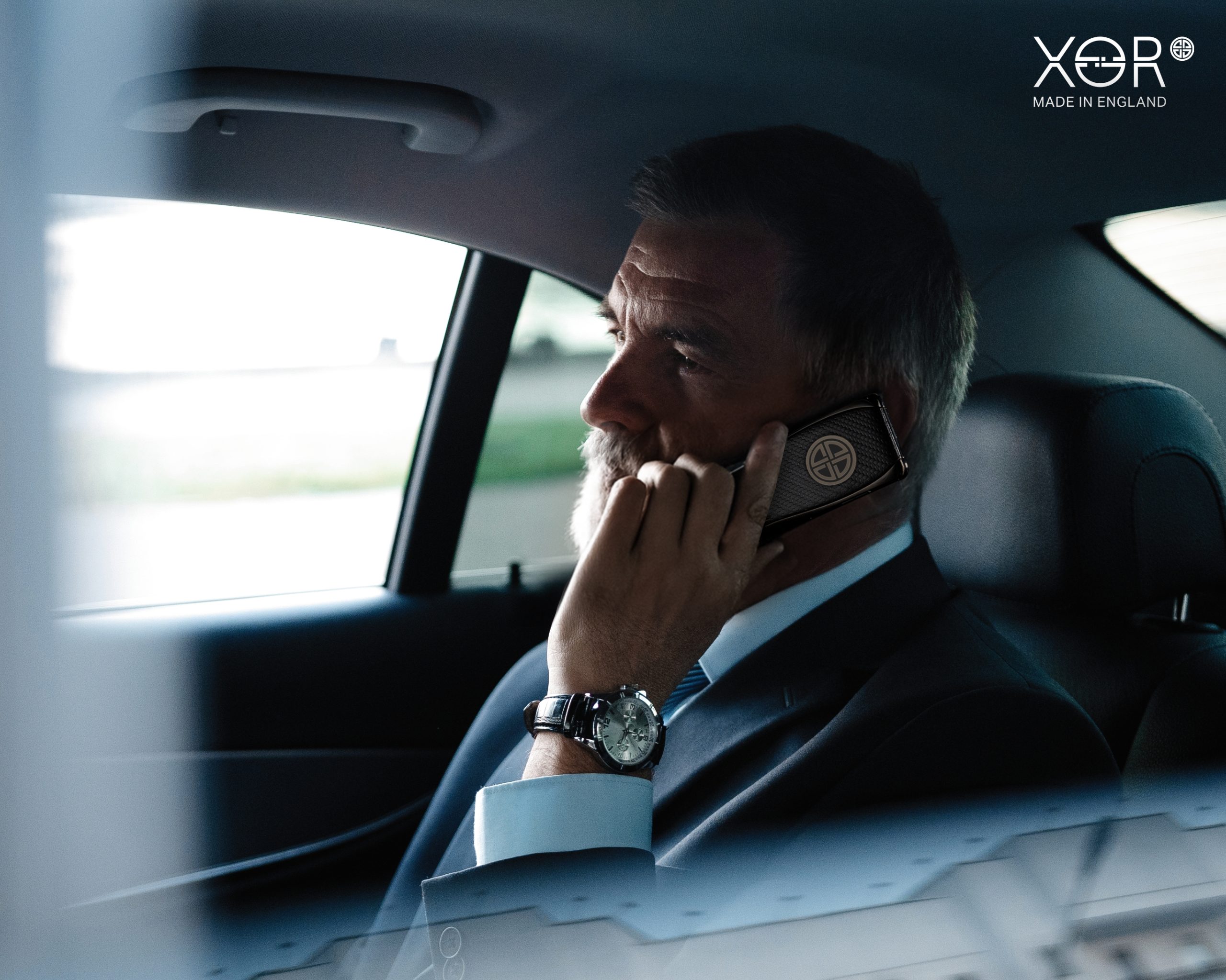 Businessman using XOR secure phone — a luxury device for privacy and security.